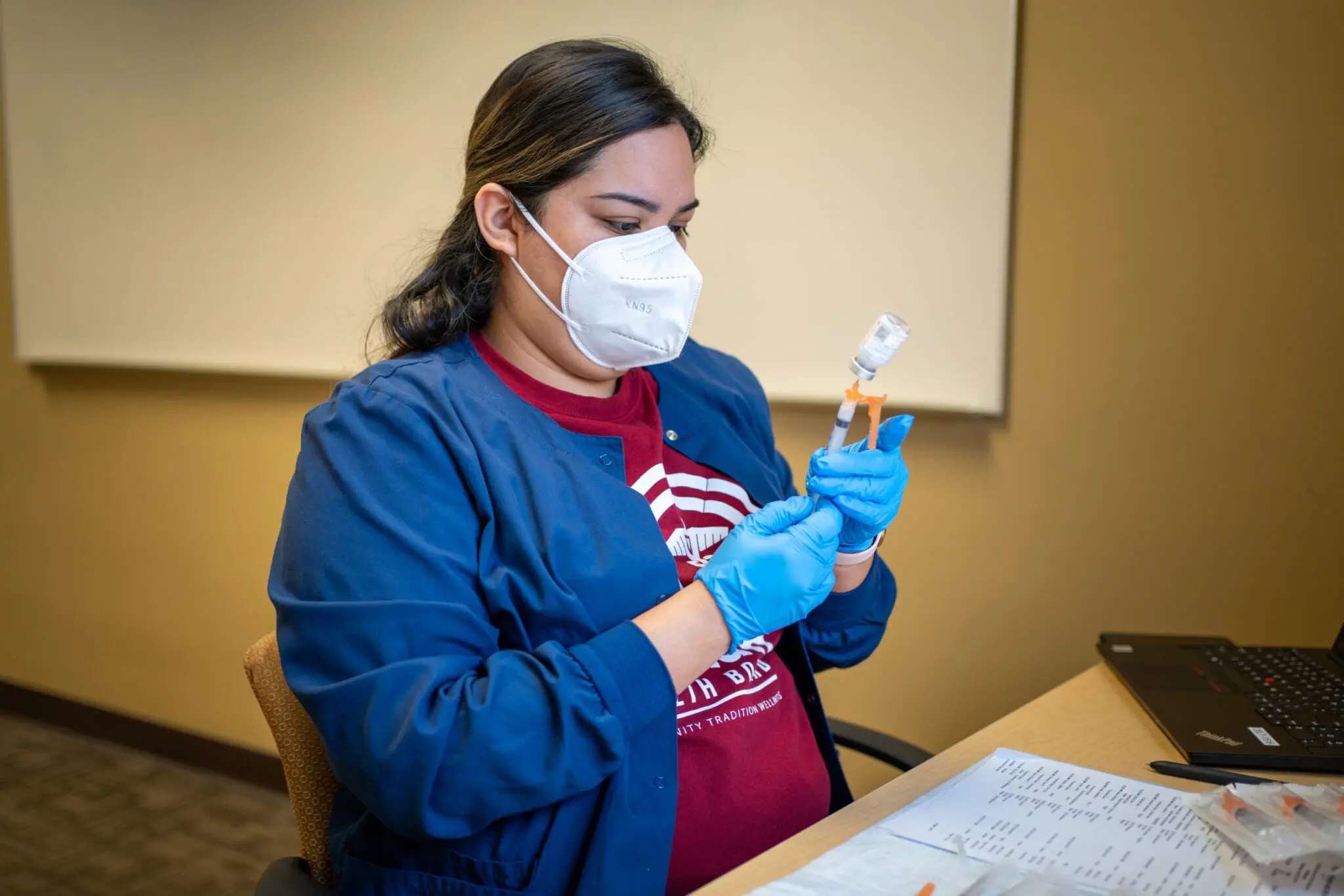 A Healthcare works holding a syringe
