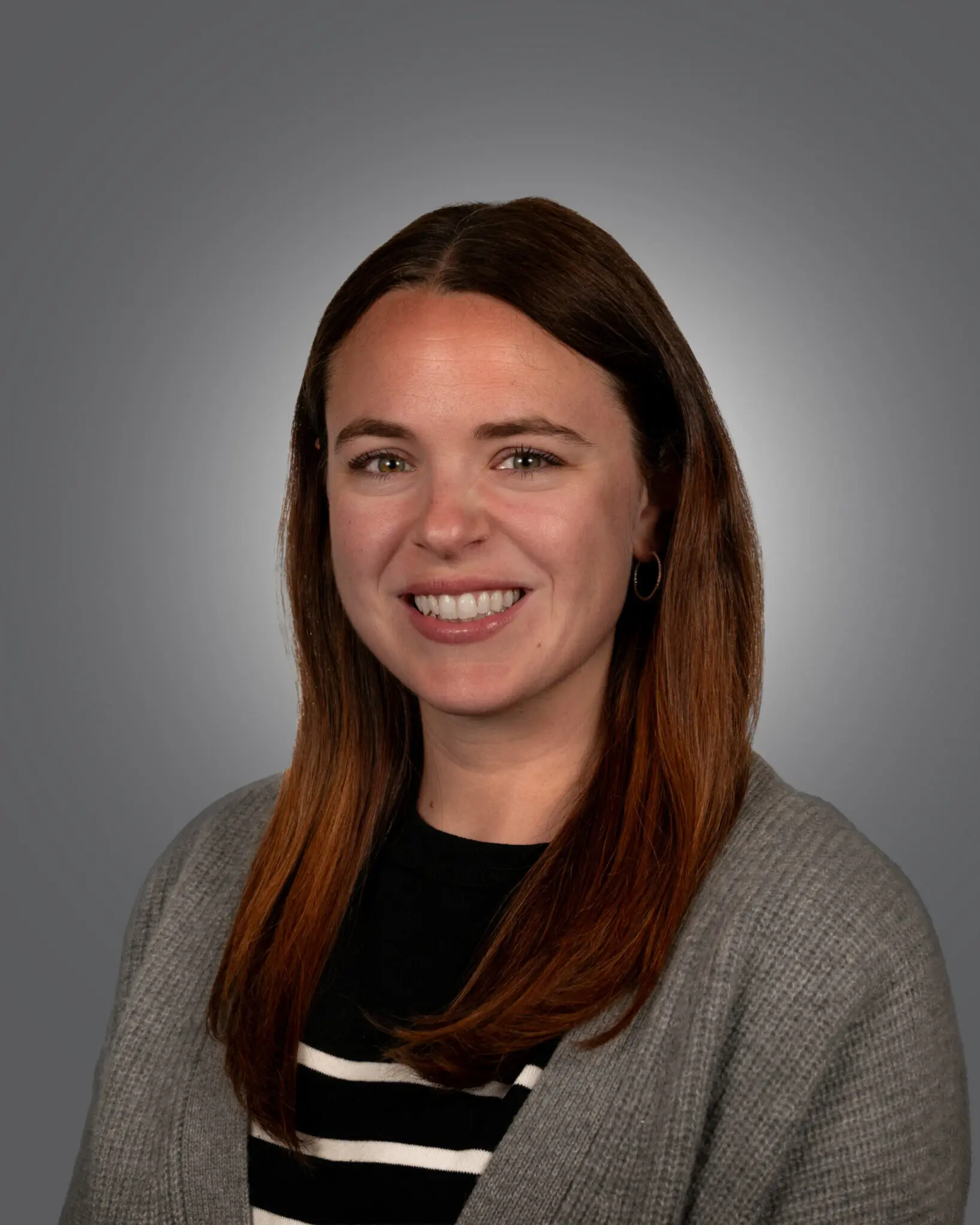 a person with long brown hair smiling