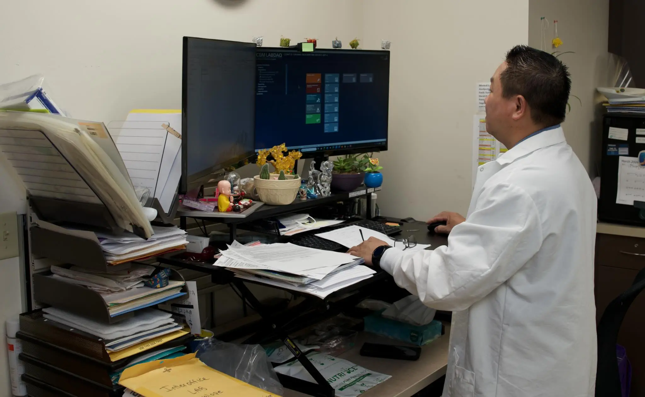 a person in a white coat working on a computer