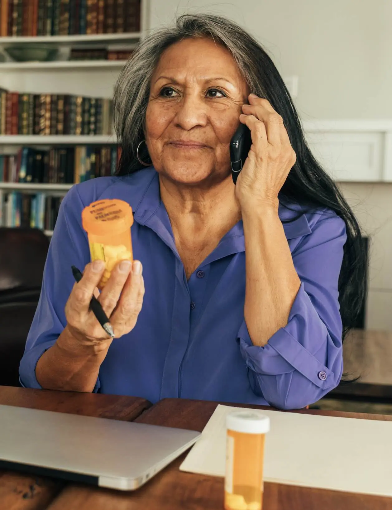 a person holding a prescription bottle and talking on a phone
