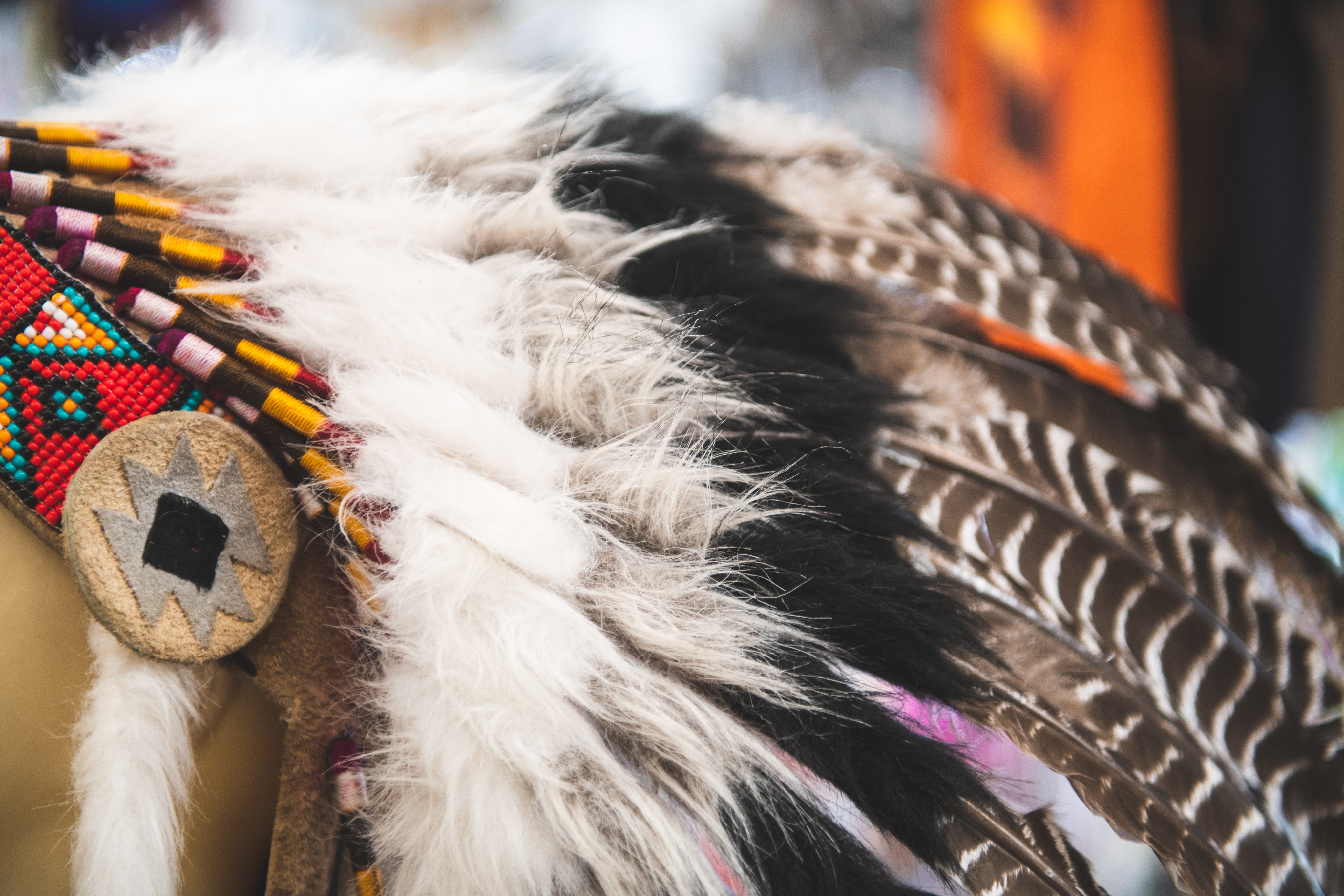 Close-up of a traditional Native American headdress with feathers and colorful beadwork